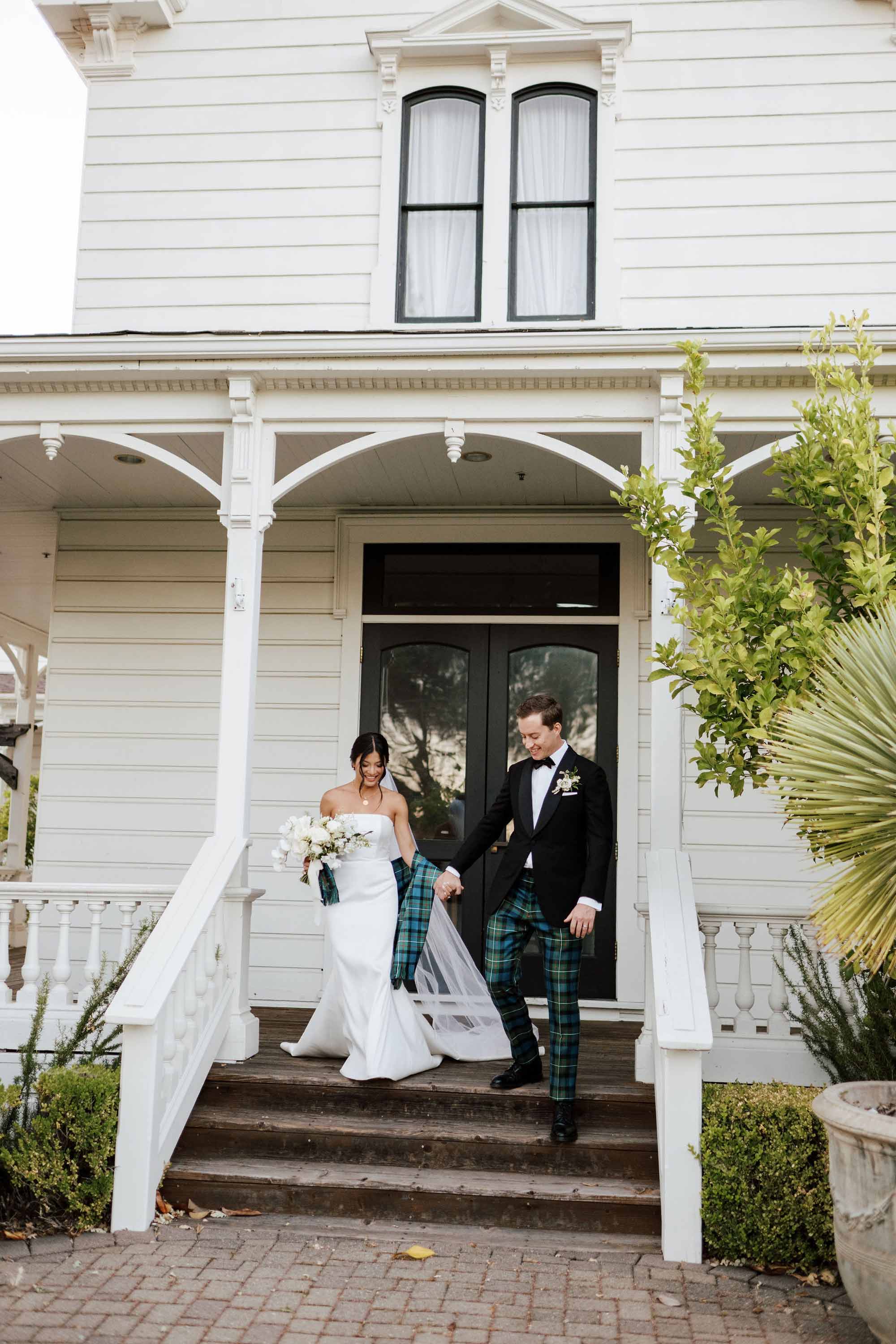 groom being a gentleman helping her wife go down the stairs