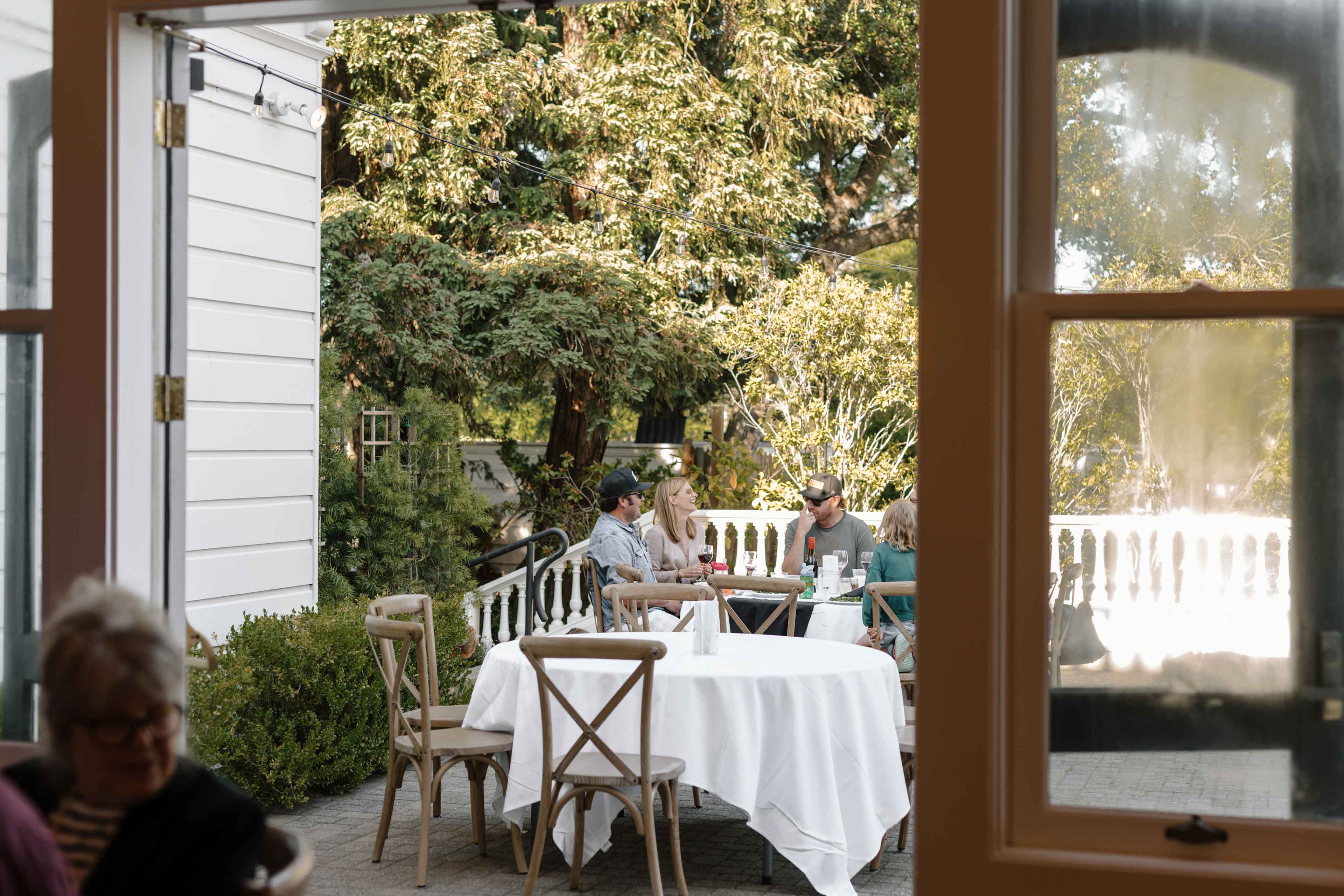 people enjoying their meal in the outside patio of the generals daughter during pizza and pinot