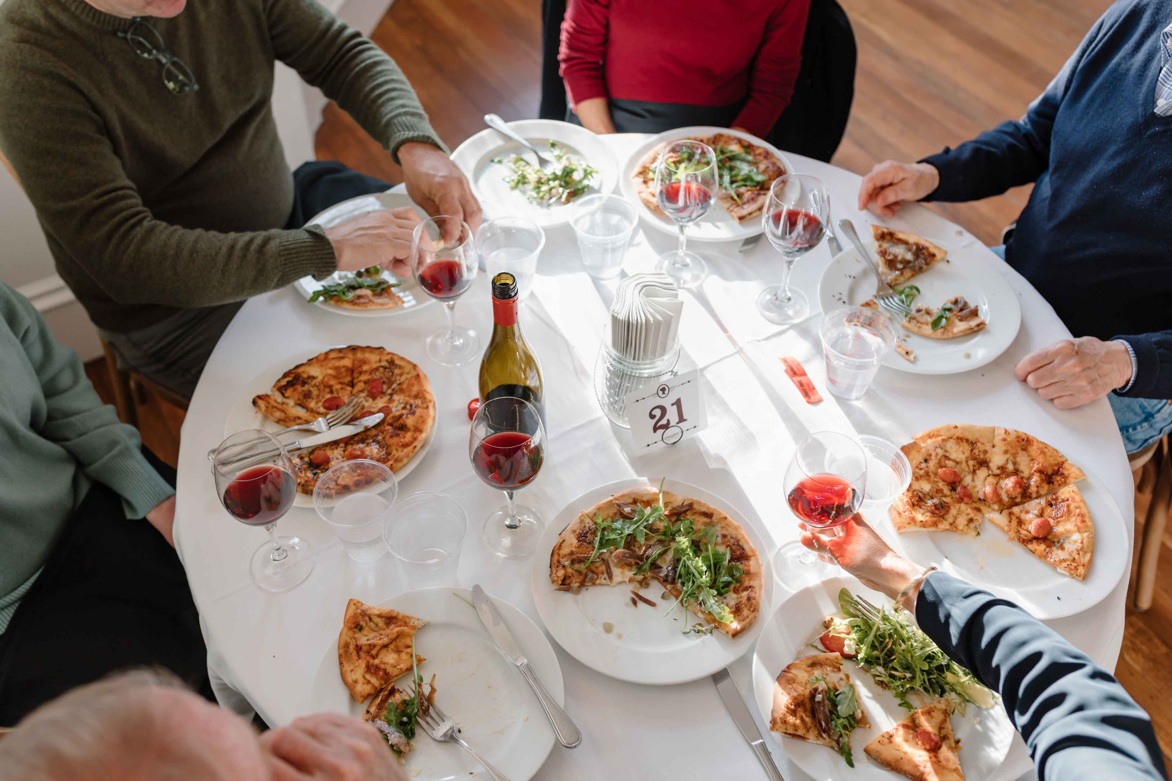 people having a great time eating pizza and wine at pizza and pinot on the generals daughter